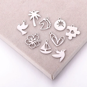 Detailed close-up of 8 stainless steel botanical and animal charms for DIY jewelry making