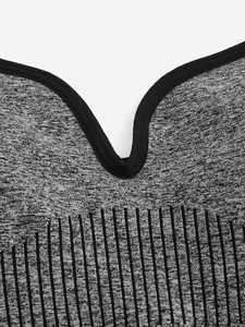 Close-up of heather grey seamless sports bra with black trimmed V-neck and ribbed texture