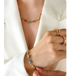 Model wearing vintage gold jewelry set with colorful zircons and safety pin ring