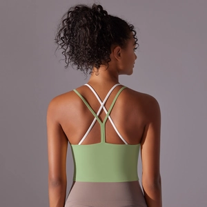 Détail des bretelles croisées vert et blanc sur un soutien-gorge de sport en nylon