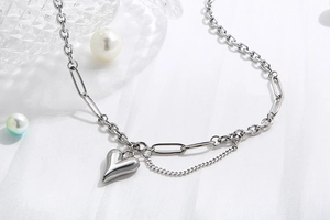 Vista macro di una collana in acciaio al titanio argento con design a pendente a cuore
