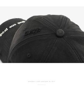 Gros plan d'une casquette de baseball noire usée avec broderie blanche et texture en coton