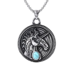 Macro shot of silver unicorn pendant featuring a detailed relief and inlaid turquoise gem