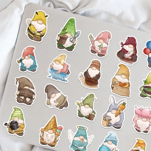 Detailed flat lay of colorful watercolor gnome stickers on a sleek laptop surface