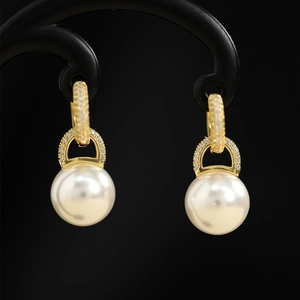 Detail of long pearl drop earrings with gold metal base and sparkling zircon accents