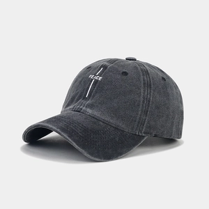 Close-up of white PEACE embroidery on dark grey washed cotton baseball cap texture