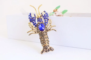 Detailed macro view of a vintage lobster keychain with blue rhinestones and gold plating