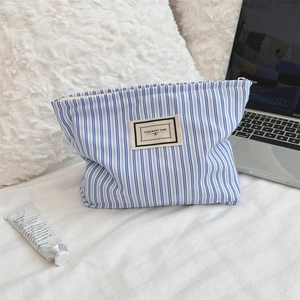 Detail of blue striped cotton canvas makeup bag with Pleasant Time fabric label