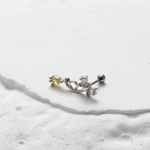 Detail of silver stainless steel barbell stud with yellow marquise zirconia butterfly