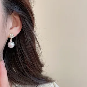 Close-up of elegant pearl drop earring with sparkling micro-inlaid zircon metal base