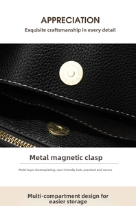 Close-up of golden magnetic buckle on black lychee grain leather bag with compartments