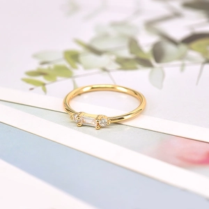 Macro view of minimalist 18k gold ring with rectangular zircon and side diamond accents
