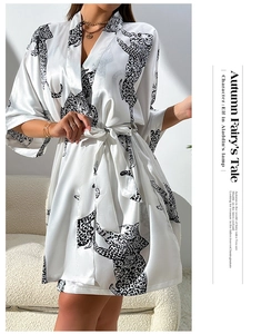 Detail of satin robe with leopard print and waist tie shown in a minimalist home setting