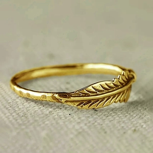 Macro-opname van een vintage gouden veren ring met fijne geborstelde metaaltexturen