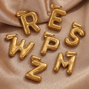 Mini 18K gold-plated stainless steel bubble letter charms on shimmering fabric