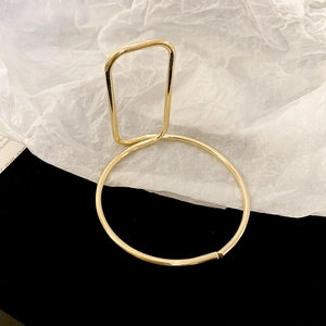 Detailed view of luxury gold teardrop open bangle with creative geometric hollow design