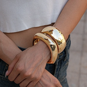 Pair of minimalist chunky golden geometric acrylic bracelets with polished mirror finish