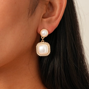 Baroque style gold-plated earrings set with pearls and rhinestones on a female model