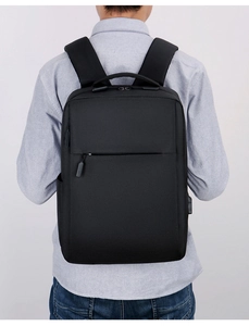 Detail of ergonomic padded shoulder straps and USB charging port on a black laptop backpack