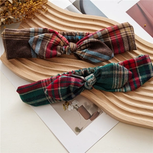 Detail of plaid bow headbands in red and green colors on an artistic wooden tray