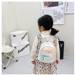 Girl's backpack with sequined rabbit ears and pink mesh bow detail on a white model