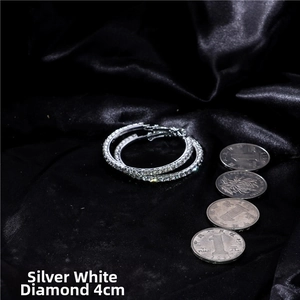 Macro shot of 4cm silver hoop earrings with white crystals on black silk fabric