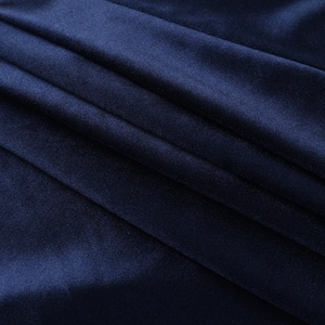Gros plan détaillé d'un tissu en satin bleu marine avec des drapés élégants et doux