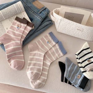 Détail de chaussettes à rayures avec texture en tricot fin et broderies d'ours mignonnes