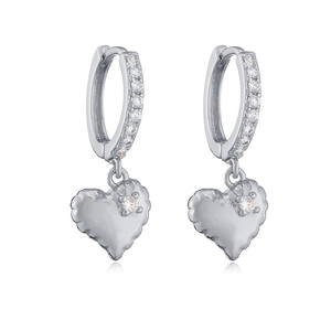Detailed macro view of silver heart earrings with quilted texture and sparkling zircon pavé