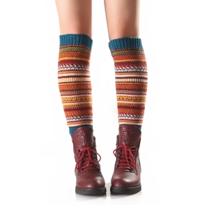 Détail de jambières en tricot aux motifs bohèmes portées avec des bottines en cuir