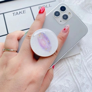 Close-up of the galaxy nebula phone grip stand mounted on a smartphone held in hand