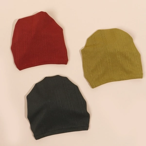 Détail de la maille de trois bonnets pour bébé en bordeaux, olive et anthracite