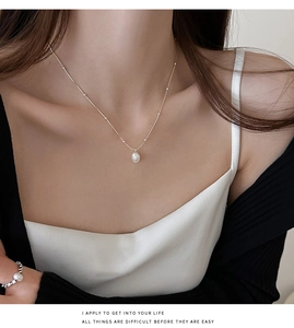 Baroque freshwater pearl pendant on a delicate stainless steel chain worn by a model