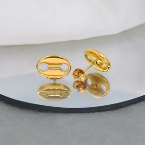 Macro detail of golden oval mariner link stud earrings with mirror reflection effect