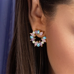 Close-up of multicolor marquise-cut crystal hoop earrings on a model's ear with gold finish