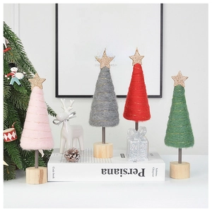 Detail of four mini wool felt Christmas trees with gold stars and natural wood bases