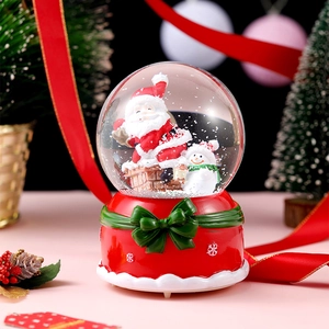 Close-up of a Christmas crystal ball featuring Santa Claus and a snowman inside