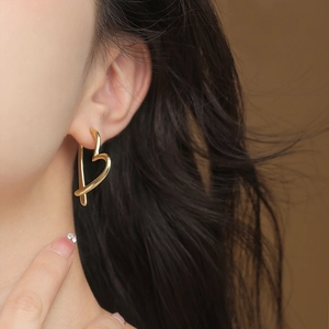 Elegant S925 silver minimalist heart-shaped gold earrings worn by a model in close-up