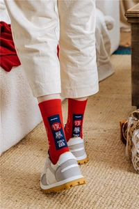 Detail of red festive crew socks with Chinese characters worn with white retro sneakers