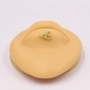 Gold crescent moon cartilage stud with sparkling crystals shown on an ear model