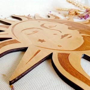 Detailed close-up of a laser-cut wooden sun wall decor with bohemian star patterns