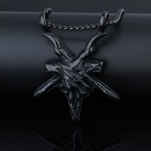 Close-up of a punk-style black stainless steel demon claw pendant on a metal chain