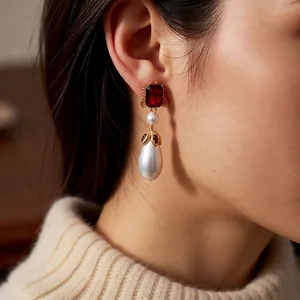 Vintage style drop earrings featuring ruby red stones and teardrop pearls in gold settings