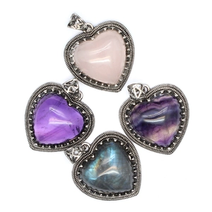 Detailed view of four heart-shaped natural stone pendants in retro silver frames