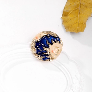Vintage sun and moon face brooch in deep blue enamel and gold finish on a plate