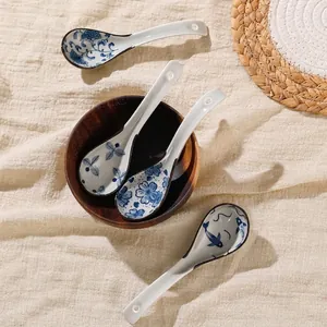 Japanese ceramic soup spoons with blue and white porcelain patterns on wooden bowl