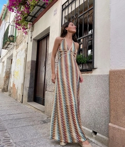 Detailed close-up of bohemian crochet knit texture and colorful wave patterns on long dress