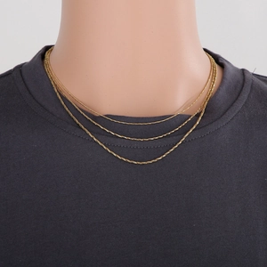 Three-layer golden snake chain necklaces shown on neck model for layered jewelry styling