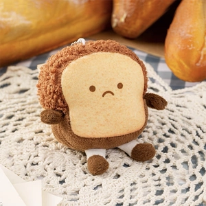 Close-up of a cute plush toast keychain with tiny legs on a cozy bakery background