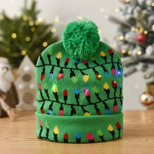 Detail of green knit Christmas hat with colorful glowing LED lights on wooden surface